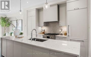 Mississauga (Mineola) townhouse for rent - A modern kitchen with white cabinets and a marble countertop.