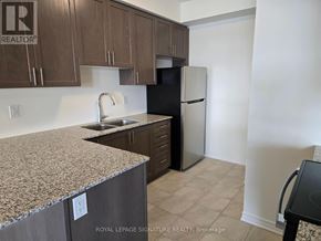 Brampton (Northwest Brampton) townhouse for rent - A kitchen with brown cabinets and a granite countertop.