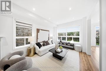 Mississauga (Churchill Meadows) apartment for rent - A modern living room with a white sofa and a grey armchair.