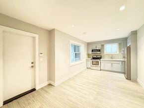 Surrey apartment for rent - A kitchen with white cabinets and a microwave above the stove.