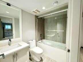 Surrey apartment for rent - A white toilet is in a bathroom with a glass shower door.