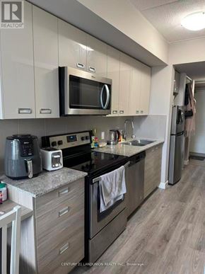 Waterloo condo for rent - A kitchen with a microwave, oven, and sink.