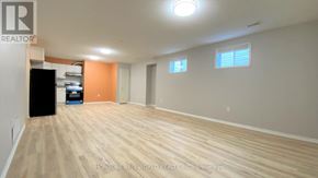 Barrie (Georgian Drive) apartment for rent - A room with wooden flooring and a black trash bin.