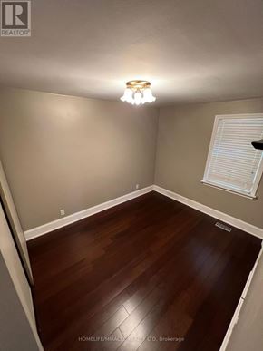 Toronto (Clairlea-Birchmount) apartment for rent - A room with wooden flooring and a light fixture on the ceiling.