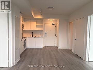 Toronto (Dovercourt-Wallace Emerson-Junction) condo for rent - A kitchen with white cabinets and a wooden floor.