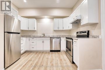 Central Huron (Clinton) multi-family for rent - A kitchen with white cabinets and a stainless steel refrigerator.