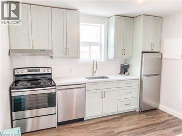 Kitchener apartment for rent - A kitchen with white cabinets and a stainless steel refrigerator.