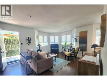 Vancouver apartment for rent - A living room with a couch, chair, and a table with a lamp on it.