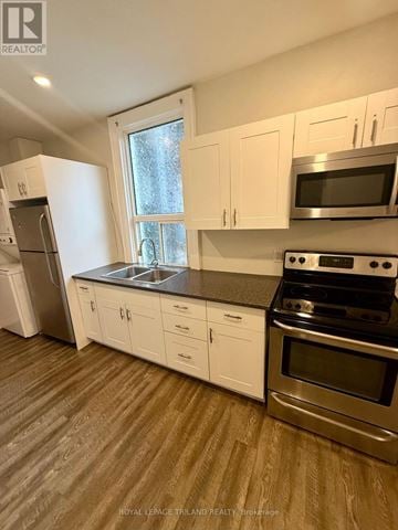 London East (East F) multi-family for rent - A kitchen with white cabinets and stainless steel appliances.