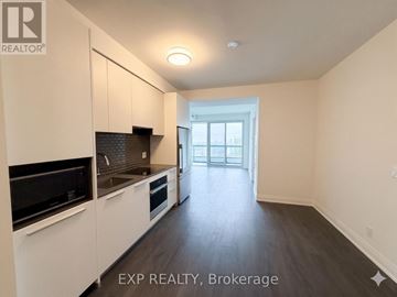 Toronto (Mount Pleasant West) condo for rent - A kitchen with white cabinets and black appliances is shown.