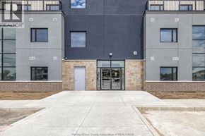 Lasalle condo for rent - The image shows the front of a building with a grey and black facade, a glass door entrance, and a brick base.