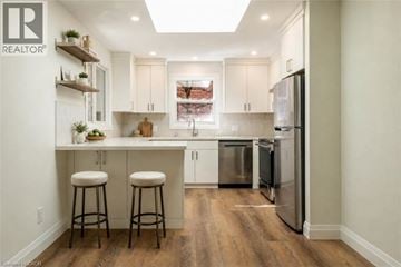 Milton apartment for rent - A modern kitchen with white cabinets and a stainless steel refrigerator.
