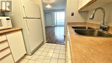 Toronto (Willowdale East) condo for rent - A kitchen with a white refrigerator, sink, and brown countertop.