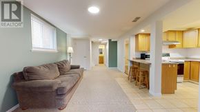 Guelph (Kortright West) apartment for rent - A realtor logo is on the wall in a living room.