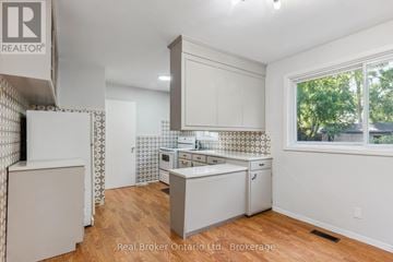 Kitchener apartment for rent - A kitchen with white cabinets and a wooden floor.