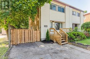 Kitchener apartment for rent - A house with a wooden fence and a small tree in front.