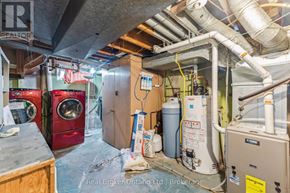 Kitchener apartment for rent - A room with a washing machine, dryer, and a furnace.