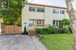 Kitchener apartment for rent - A two-story house with a garage and a tree in front.