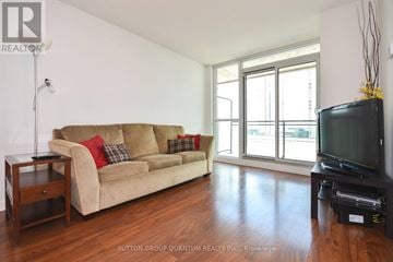 Toronto (Waterfront Communities) condo for rent - A living room with a tan couch and a black television.