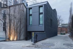 Toronto (Annex) apartment for rent - A modern house with a black facade and a garage door is shown.