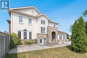 Orillia apartment for rent - A large, two-story house with a stone archway entrance and a brick chimney.