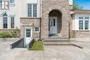 Orillia apartment for rent - A stone house with a grey door and windows.