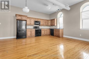 Tillsonburg multi-family for rent - A kitchen with wooden cabinets and black appliances.