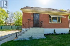 Sarnia apartment for rent - A small red brick house with a black door and a small porch.