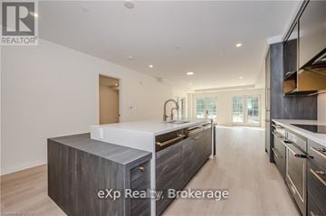 Centre Wellington (Elora/Salem) condo for rent - A modern kitchen with a large island and stainless steel appliances.