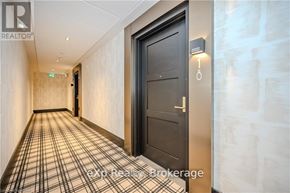 Centre Wellington (Elora/Salem) condo for rent - A hallway with a black door and a sign that says "REALTOR".
