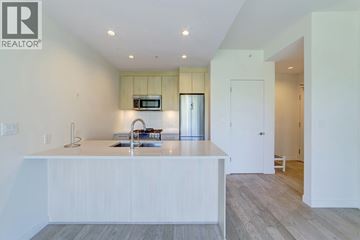 Burnaby apartment for rent - A modern kitchen with white cabinets and a wooden floor.