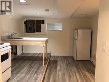 Burnaby apartment for rent - A kitchen with a table and a refrigerator.