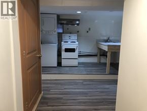 Burnaby apartment for rent - A kitchen with a white fridge, stove, and sink.