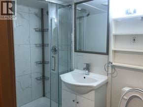 Burnaby apartment for rent - A white sink in a bathroom with a glass shower door.