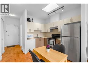 Vancouver apartment for rent - A kitchen with a table and chairs in the foreground and a refrigerator in the background.