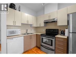 Vancouver apartment for rent - A kitchen with a black stove top oven, white dishwasher, and a white microwave.