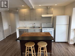 Guelph (Exhibition Park) apartment for rent - A kitchen with white appliances and wooden stools.