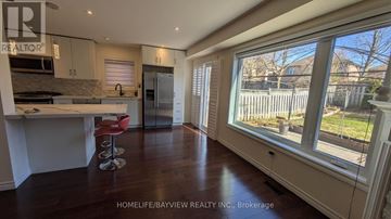 Richmond Hill (Oak Ridges) apartment for rent - A kitchen with white cabinets and a red bar stool.