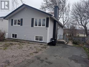 St. John's multi-family for rent - A house with a grey siding and a black chimney is for sale.
