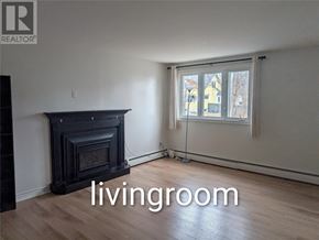 St. John's multi-family for rent - A living room with a fireplace and a window.