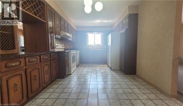 Brantford apartment for rent - A kitchen with wooden cabinets and a tiled floor.