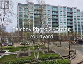 Markham (Unionville) condo for rent - A view of a courtyard with a building in the background and the text "Balcony Photo 2 - facing courtyard" overlaid on the image.