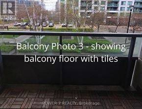 Markham (Unionville) condo for rent - A balcony with tiled flooring and a view of a parking lot and trees.