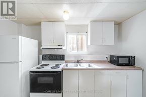 Welland (N. Welland) apartment for rent - A white kitchen with a black oven and microwave.