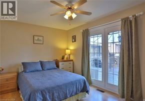 Kitchener apartment for rent - A bedroom with a bed, nightstand, and sliding glass doors.