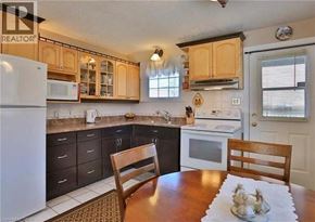 Kitchener apartment for rent - A kitchen with a white fridge and wooden chairs.