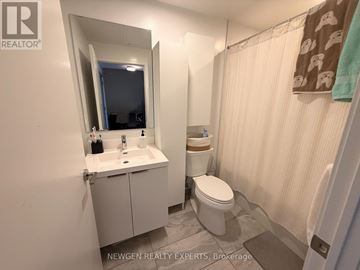Toronto (Banbury-Don Mills) condo for rent - A bathroom with a toilet, sink, and mirror.