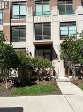 Toronto (Forest Hill South) house for rent - A building with a brown door and windows with trees in front.