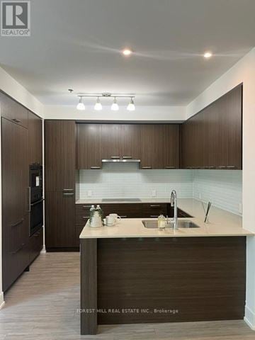 Toronto (Forest Hill South) house for rent - A modern kitchen with dark wood cabinets and a white countertop.