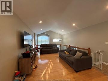 Windsor apartment for rent - A living room with a grey couch and a television on the wall.